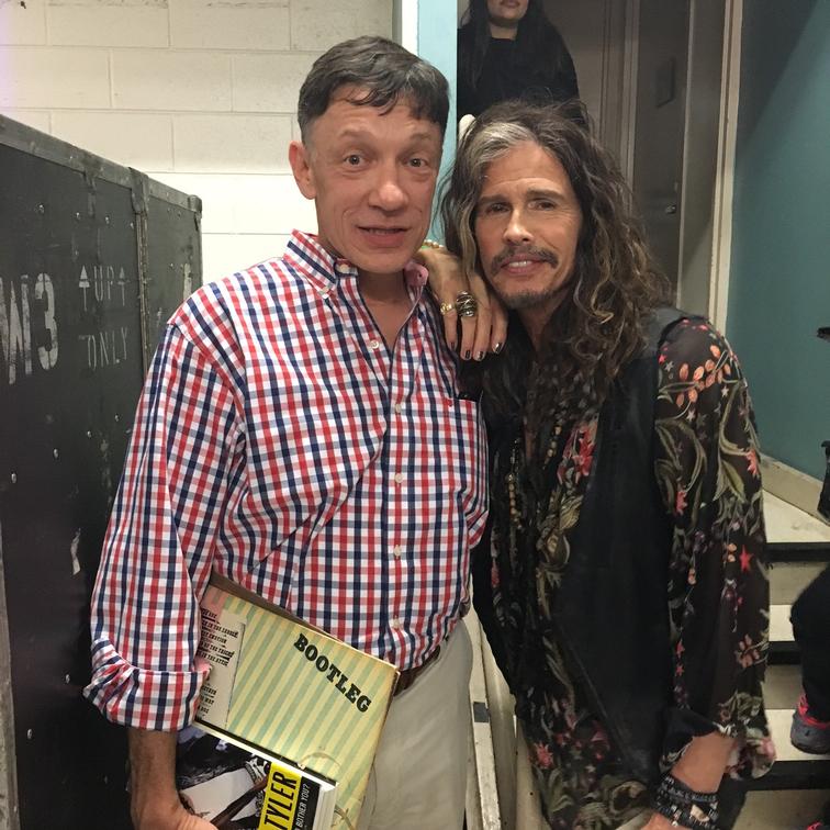 Daniel Buccino and Steve Tyler of Aerosmith have their arms around each other. 